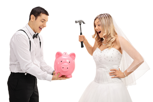 bride and groom about to break a piggy bank to pay for their wedding