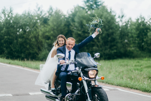 wedding couple getting eloped and riding on a motorbike